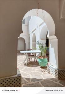 a table and a chair in a room with white walls at Hostel amodou in Tinerhir
