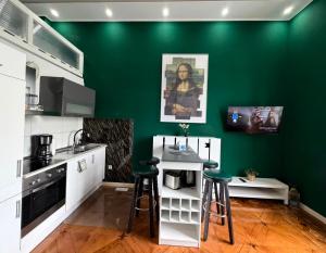 a kitchen with a green wall and stools in it at Oxford Royal Apartment - Nähe Bahnhof in Bremen