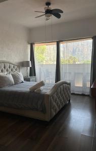 a bedroom with a large bed with a ceiling fan at Sierra Central By Chic Hotel Group in Tepoztlán