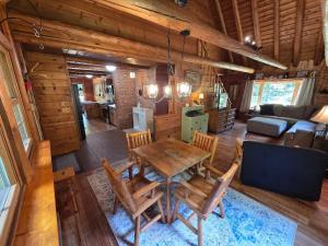 a dining room and living room of a log cabin at Highlands Hideaway - Secluded 4BR Forest Gem in Chemung