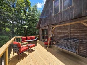 a wooden deck with chairs and a house at Highlands Hideaway - Secluded 4BR Forest Gem in Chemung