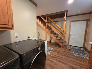 a laundry room with a washer and a staircase at Highlands Hideaway - Secluded 4BR Forest Gem in Chemung +63 photos