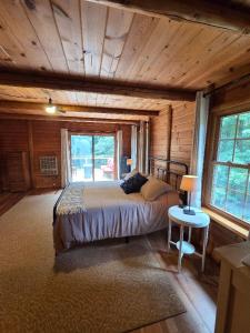 a bedroom with a bed in a log cabin at Highlands Hideaway - Secluded 4BR Forest Gem in Chemung