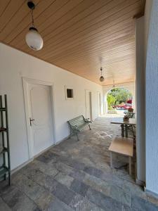 an empty room with a bench and a table at Villa Filoxenia Studios Alykes in Katastárion