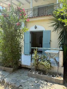 a house with blue shutters and a balcony at Villa Filoxenia Studios Alykes in Katastárion +7 photos