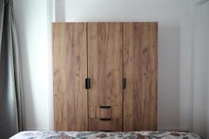 a wooden cabinet in a bedroom next to a bed at Sottomarina Suite Palazzo Storico in Chioggia