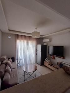 a living room with a couch and a refrigerator at Le charment in Sukrah +4 photos