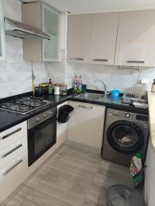 a kitchen with a stove and a washing machine at Le charment in Sukrah