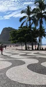 a walkway on a beach with palm trees and the ocean at VILA LEME Casa 11 in Rio de Janeiro