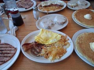 a table with plates of breakfast food on it at The Jeffreys Hotel Extended Stay in Osceola