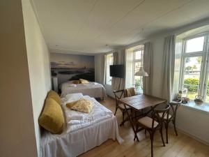 a bedroom with two beds and a table and a desk at Restaurant Backhaus in Ribe
