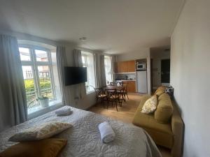 a bedroom with a bed and a couch and a kitchen at Restaurant Backhaus in Ribe