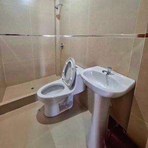 a bathroom with a toilet and a sink at Delcor Suite in Piura