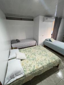 a room with three beds in a room at Casa Delfín in Tortuguero