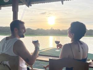 a man and woman sitting on a boat drinking wine at Casa Delfín in Tortuguero