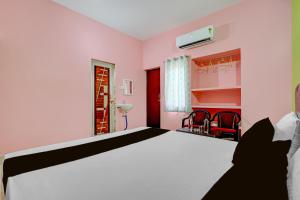 a bedroom with a large bed and red chairs at Hotel O Muna Heritage Guest House in Cuttack