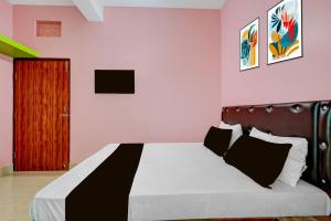 a bedroom with a bed with a black and white blanket at Hotel O Muna Heritage Guest House in Cuttack +69 photos