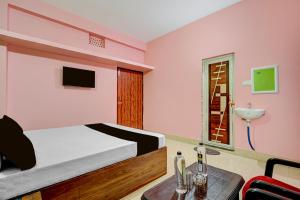 a pink bedroom with a bed and a table at Hotel O Muna Heritage Guest House in Cuttack