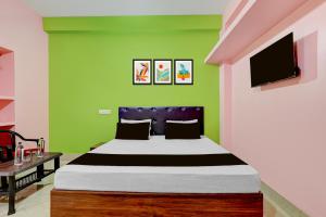 a bedroom with a bed and a green wall at Hotel O Muna Heritage Guest House in Cuttack