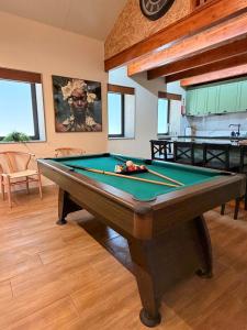 a pool table in a living room with a clock at Encantos da Aldeia - Casa da Pedra in Oliveira de Azemeis