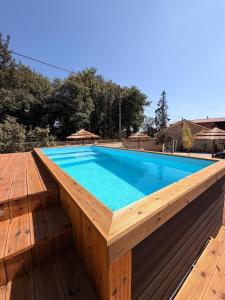 a swimming pool with a wooden deck and a swimming poolvisor at Encantos da Aldeia - Casa da Pedra in Oliveira de Azemeis