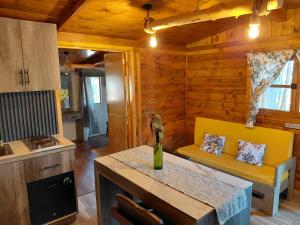 a living room with a yellow couch and a kitchen at El descanso casa-hotel zacatlán. in Zacatlán