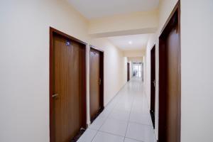 an empty hallway with wooden doors and a hallwayngth at Hotel O M3M Paradise in Bhiwadi