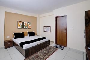 a bedroom with a bed and a wooden door at Hotel O M3M Paradise in Bhiwadi