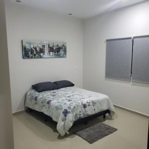 a bedroom with a bed with a painting on the wall at Torre Monaco en Sabalo Country in Mazatlán
