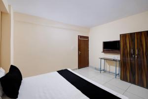 a bedroom with a bed and a desk in it at Hotel O M3M Paradise in Bhiwadi +68 photos