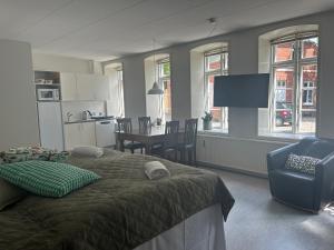 a bedroom with a bed and a kitchen with a table at Restaurant Backhaus in Ribe