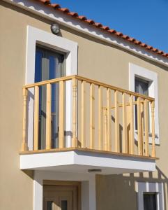 a wooden balcony on the side of a house at Lithos Heritage in Líkhna