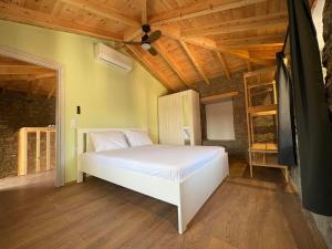 a bedroom with a white bed and a wooden ceiling at Lithos Heritage in Líkhna