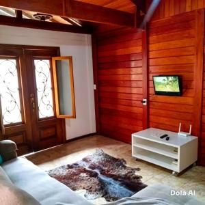 a living room with a couch and a tv at Alfa Serra lago e montanha in Guapimirim