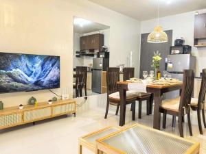 a kitchen and dining room with a table and a tv at Spacious Studio w Pool, Gym, Smart Lock, Netflix in Puerto Princesa City