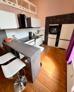 a kitchen with white cabinets and a table and chairs at Royal Rose Suite in zentraler Lage in Bremen