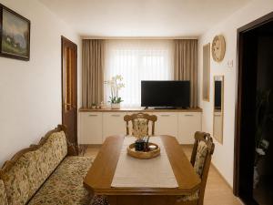 a living room with a table and a television at Apartmani Natura SH in Hodžinac