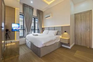 a bedroom with a large bed and a television at Zuma Tan in Lagos
