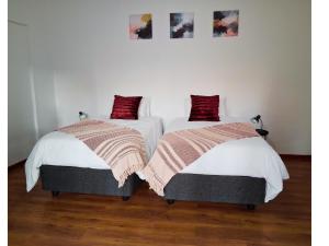 two beds sitting next to each other in a room at 30 on Latham Guesthouse in Klerksdorp