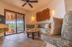 a living room with a couch and a table at Escondite condominios in Zihuatanejo