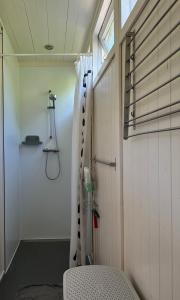 a bathroom with a shower with a curtain in it at Tiny House Madame Jeanette nabij centrum en zee in Zandvoort
