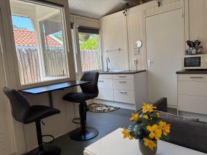 a kitchen with a table and two stools in a room at Tiny House Madame Jeanette nabij centrum en zee in Zandvoort