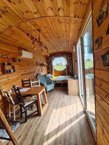 a room with a table and a bedroom in a tiny house at Slovácká maringotka in Šumice