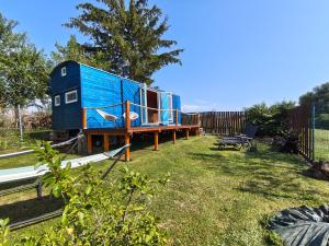 a blue tiny house sitting on top of a yard at Slovácká maringotka in Šumice
