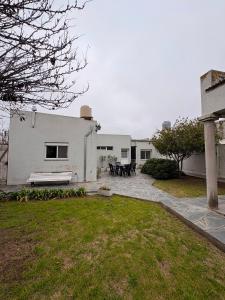 a white house with a bench in a yard at Rancho nuevo in Carhué