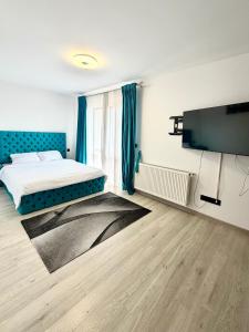 a bedroom with a bed with a blue headboard at Blue Apartment with Free Parking&Self Check-in in Bistriţa