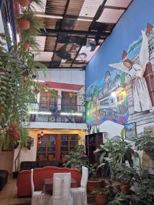 a room with plants and a large mural on the wall at hotel kasa kamelot parque in Quetzaltenango