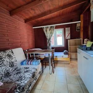 a kitchen and dining room with a table and a couch at Domki Wakacyjne nad Jeziorem in Janowice