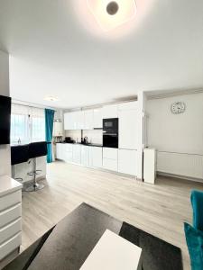 a living room with white cabinets and a kitchen at Blue Apartment with Free Parking&Self Check-in in Bistriţa