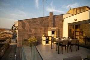 a patio with a table and chairs on top of a building at Côa River Apartment in Vila Nova de Foz Coa